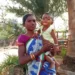 Chandrika Majhi holds her baby son outside her house in Gadadi, India.