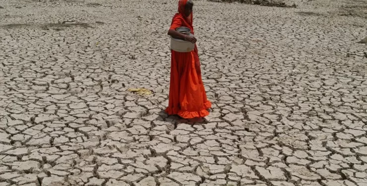 A woman crossing dry Sabarmati riverbed in India. India’s rural women are bearing the brunt of climate related shocks like severe drought and extreme weather events,